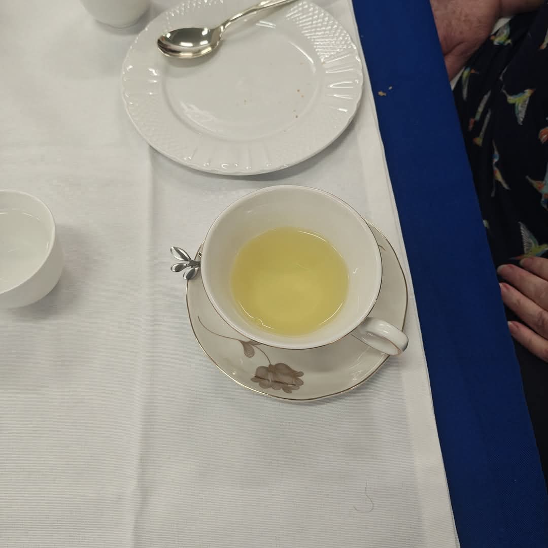 Pale golden tea in a delicate white teacup and floral saucer